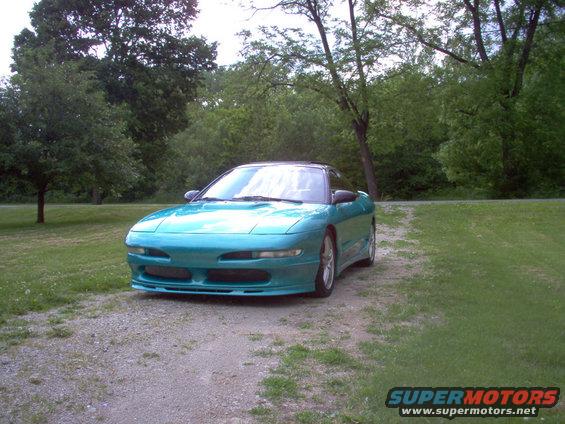 Teal 1993 Ford Probe coupe parked on a gravel driveway, front 3/4 view