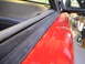 1997 Ford Probe - Close-up view of a red car's interior door panel and fender, showing damage on the exterior panel.