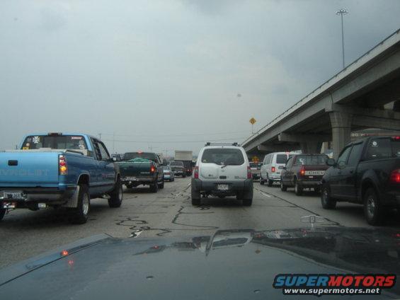 Cars stuck in traffic on a highway under an overpass. Cloudy day