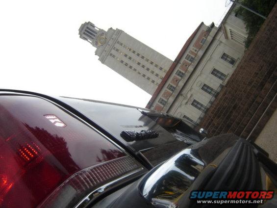 Car's rear end with a building and tower in the background