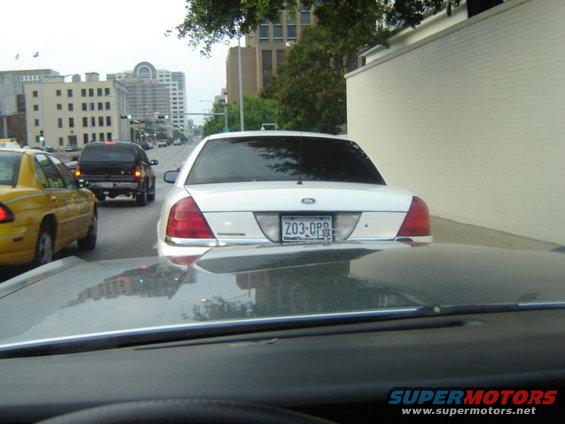 White sedan with license plate Z03-OPP in traffic, yellow taxi to the left, black SUV ahead