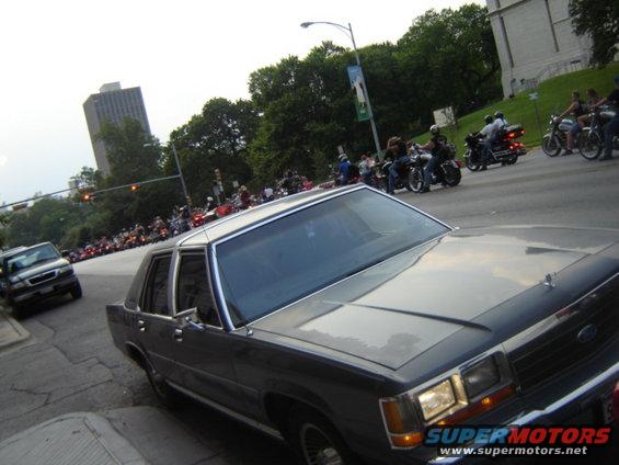 1988 Ford Crown Victoria LTD parked on street with motorcycles in background