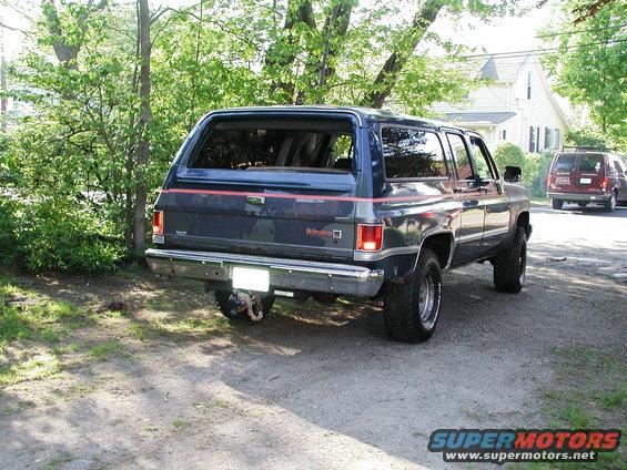Dark blue SUV with red pinstripes, lifted suspension, and chrome bumper