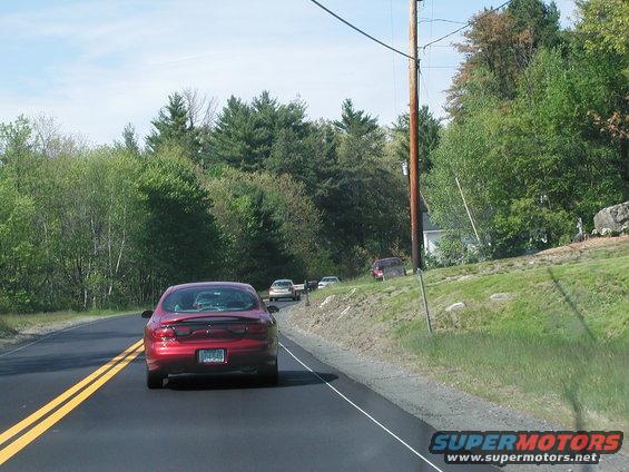 Red 1992 Ford Taurus rear view on a road