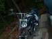 1976 Harley-Davidson Super Glide - Motorcycle parked on concrete steps outdoors.
