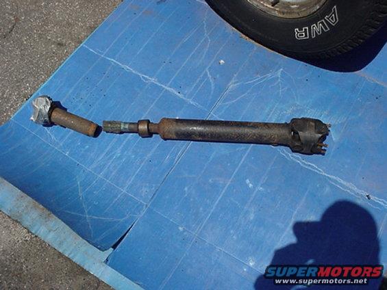 Broken driveshaft part on blue tarp