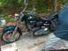 1976 Harley-Davidson Super Glide - A 1976 Harley-Davidson Super Glide motorcycle is parked on a paved surface with trees in the background.