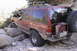 1997 Ford Ranger - This modified SUV navigates a rocky trail, its off-road capabilities with large tires and external fuel storage.