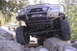 1997 Ford Ranger - A modified red Ford Ranger navigates a rocky trail, with another truck visible in the background.