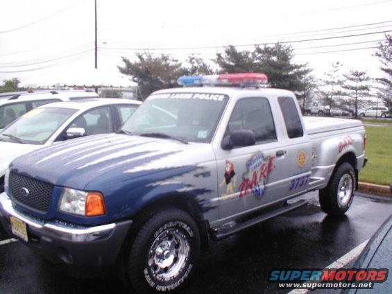Silver Ford Ranger pickup truck with blue hood, marked "LAKES POLICE DARE" and "3737"