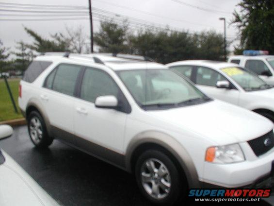 White SUV parked next to other cars. It has a two-tone paint job with a gray lower body