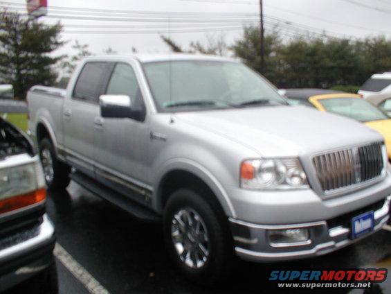 Silver pickup truck front quarter view with chrome grille and wheels
