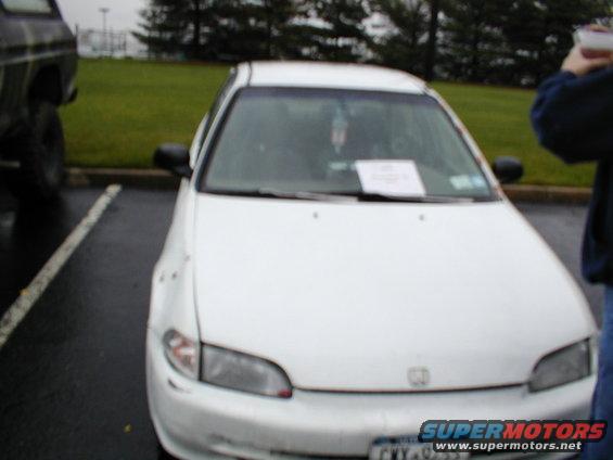 White Honda Civic front view with paper on dashboard