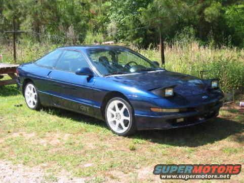Blue 1993 Ford Probe GT with white wheels parked on grass