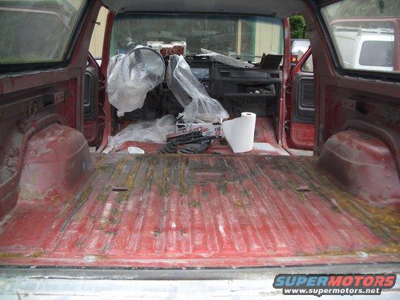 Interior of a red SUV showing the cargo area and dashboard covered in plastic