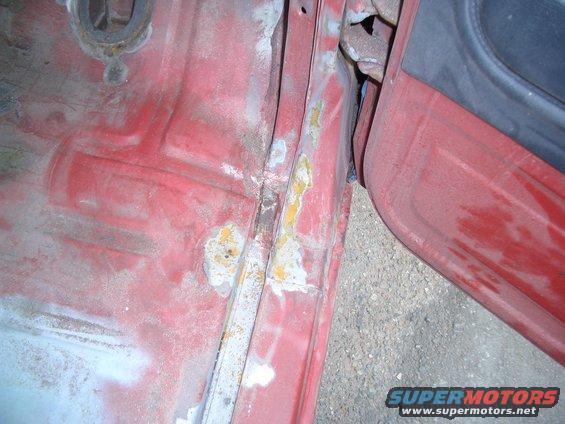 Red interior door jamb with rust and primer visible