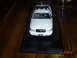 1999 Ford Crown Victoria - A white model police car is displayed on a black base, with a timestamp in the corner.
