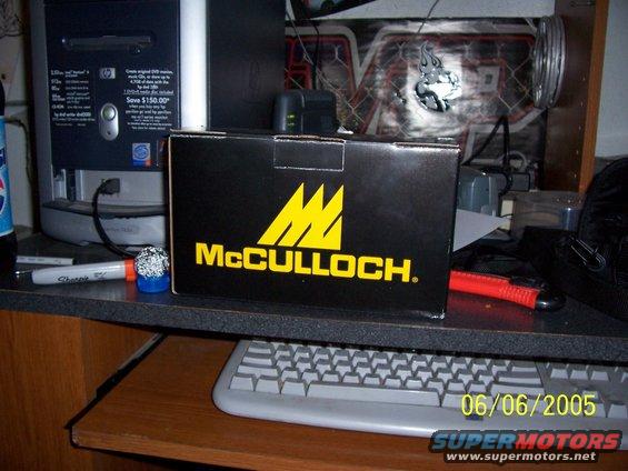 Black McCulloch box with yellow logo on desk next to computer