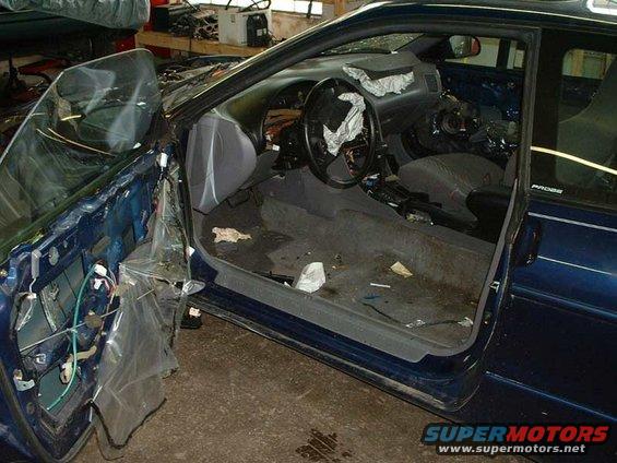 Blue car interior with door removed, showing dismantled dashboard and exposed wiring