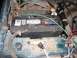 1994 Ford Bronco - A fuel injector and battery are visible in the engine bay of a vehicle.