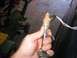 1994 Ford Bronco - A fuel injector is held in a hand, with wires connected to its top.