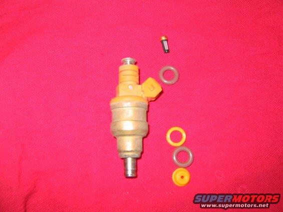 Fuel injector and O-rings on a red background. A small filter is also visible