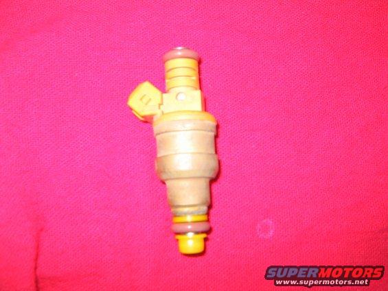 Fuel injector with yellow connector and pink and yellow O-rings against a pink background