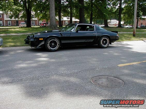 Black Z28 coupe parked on asphalt, side view. Cooper Cobra tires visible