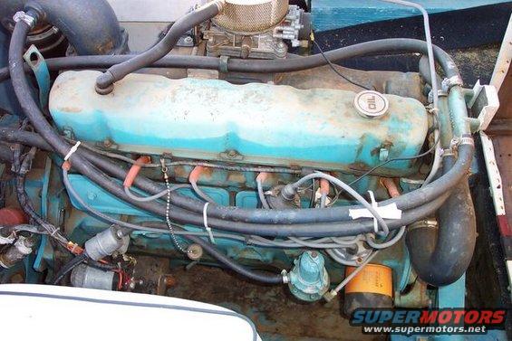 Close-up of a V8 engine with turquoise valve covers and a carburetor