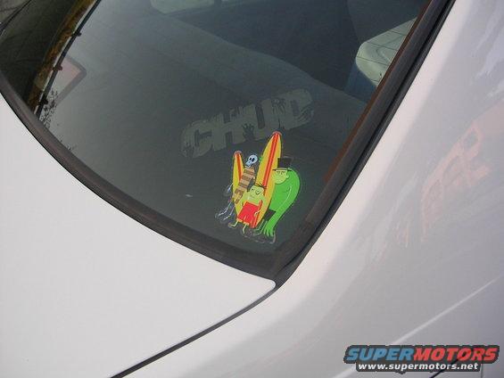 Rear window with CHUD sticker and cartoon characters with surfboards