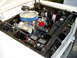 1966 Ford Fairlane - The engine bay of a 1966 Ford Fairlane shows a V8 engine with aftermarket chrome components and a prominent battery.