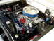1966 Ford Fairlane - The engine bay of a 1966 Ford Fairlane shows a chrome air cleaner, red spark plug wires, and various engine components.