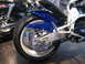 2002 Buell Lightning w/Fairing - Close-up view of a motorcycle's rear wheel and blue fender, with another motorcycle partially visible in the background.