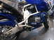 2002 Buell Lightning w/Fairing - A blue motorcycle is shown from the side, chrome details and blue exhaust pipes. Another motorcycle is visible in the background.