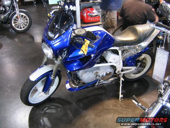 Blue and white motorcycle with a black windscreen and yellow 'SOLD' tag