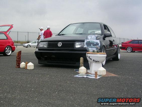 Black Volkswagen Jetta with a toilet display, front view. Modified