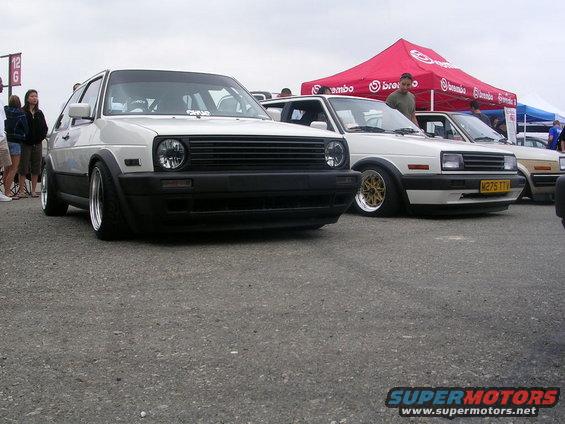 White Volkswagen Golf Mk2 GTI with black grille and fender flares, parked next to other cars