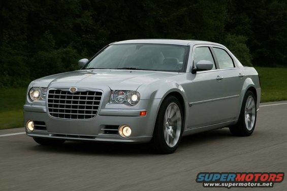 Silver sedan driving on a road, front grille and headlights visible