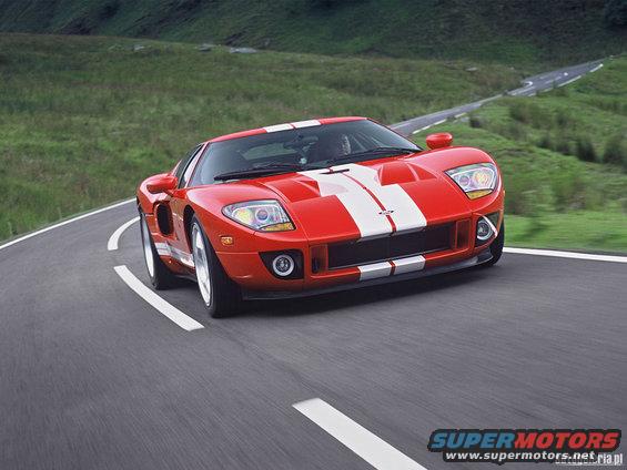 Red Ford GT with white stripes driving on a winding road