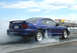 1990 Ford Bronco - A blue Ford Mustang GT performs a burnout on a drag strip, generating a large cloud of smoke.