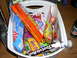 1990 Ford Bronco - A white plastic basket is filled with a variety of candy bars and wrappers, sitting on a wooden surface.