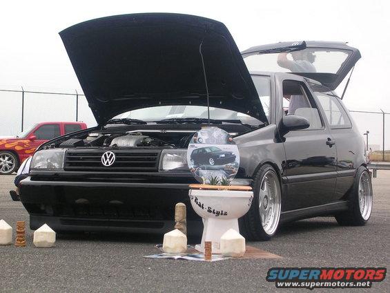 Black Volkswagen Golf Mk3 with hood and trunk open, lowered suspension, and custom wheels