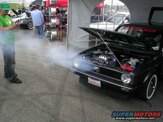 Black Volkswagen Golf Mk1 with smoke billowing from the open hood