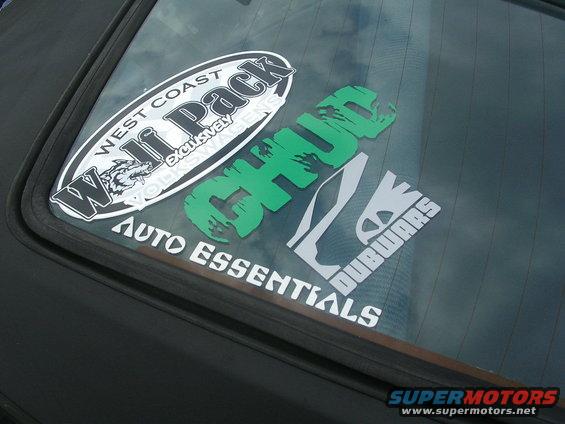 Car rear window with 'West Coast Wolf Pack', 'CHUG', and 'Dubwars Auto Essentials' stickers