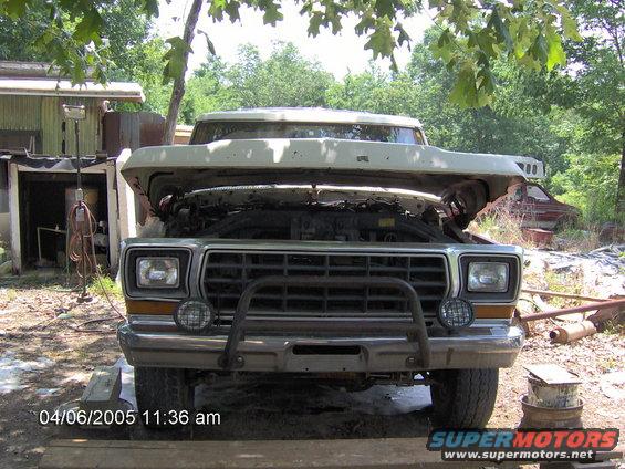 Front view of a 1979 Ford F-Series truck with hood open, showing the engine bay. It has a bull bar and auxiliary lights