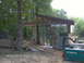 1978 Ford Bronco - A Nissan pickup truck is visible at a construction site with a partially built structure and trees in the background.