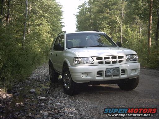 2000 Isuzu Rodeo parked on a gravel road with trees in the background. License plate reads 199-8290