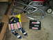 1995 Ford Bronco - A roll cage frame and Simpson restraint systems are laid out on a garage floor.