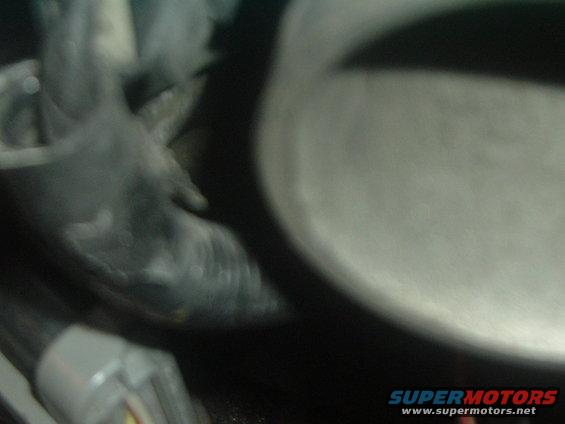 Close-up of a dark, possibly rubber hose connected to a metal component. A Supermotors.net watermark is visible
