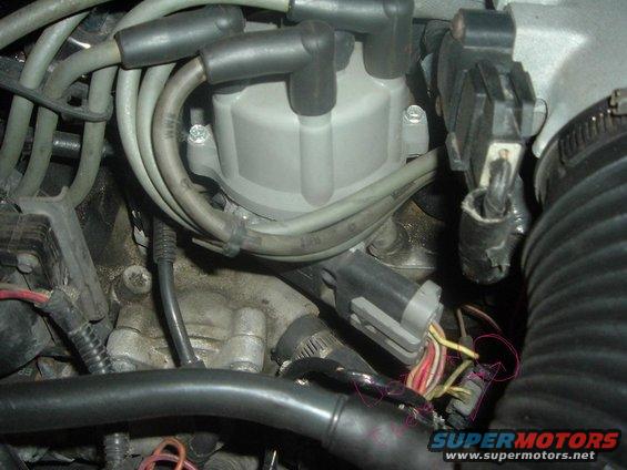 Close-up of a car's distributor cap, spark plug wires, and electrical connectors